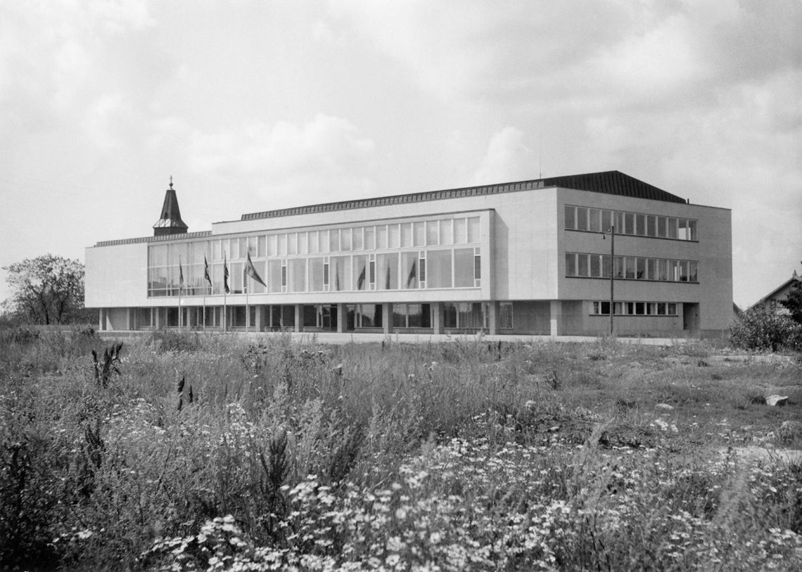 mv-kuvassa yliopiston pääkirjasto kesällä. Edustalla niitty.