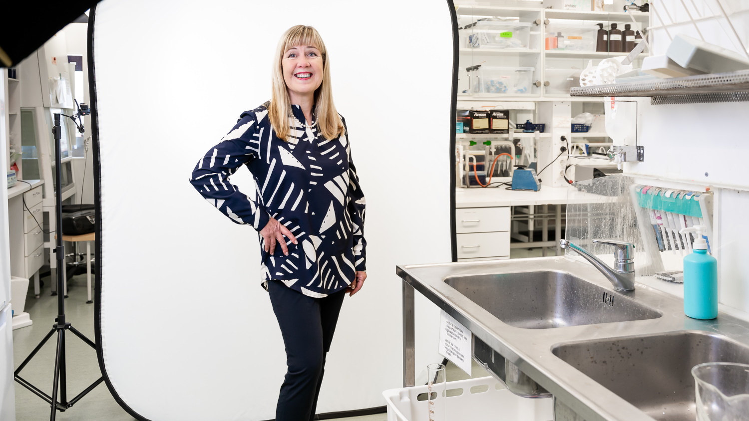 Riitta Lahesmaa seisoo laboratoriossa ja katsoo kameraan.