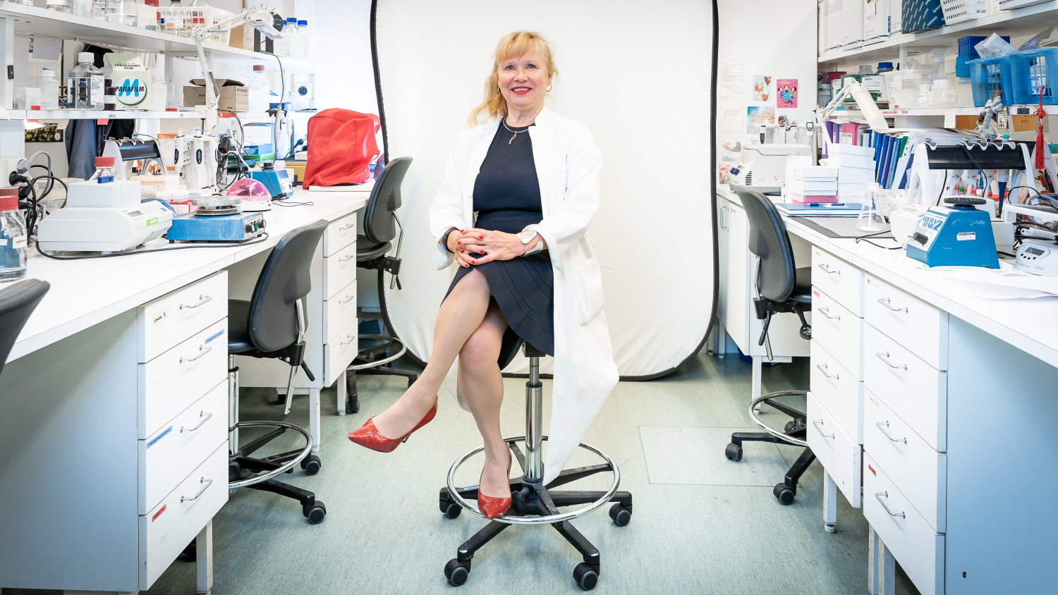 Sirpa Jalkanen istuu laboratoriossa ja katsoo kameraan.